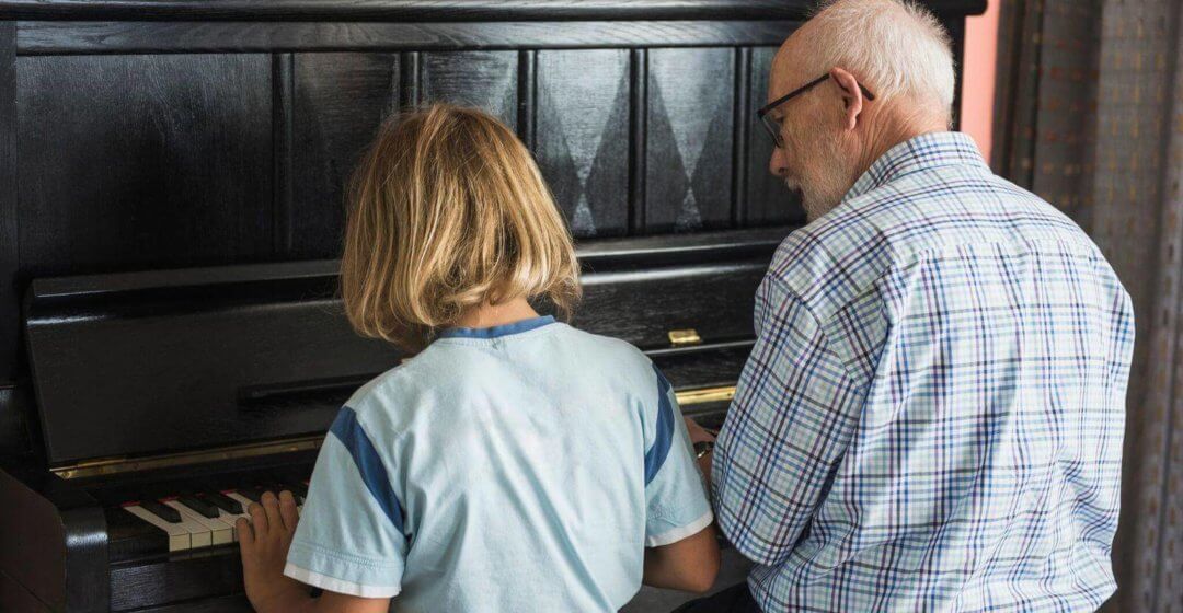 Opa und Enkel spielen am Klavier